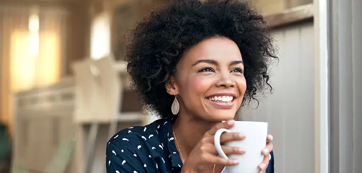 A person having a drink from a coffee mug